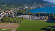 Camping des Pêches du Landeron avec les terrains de tennis en arrière-plan