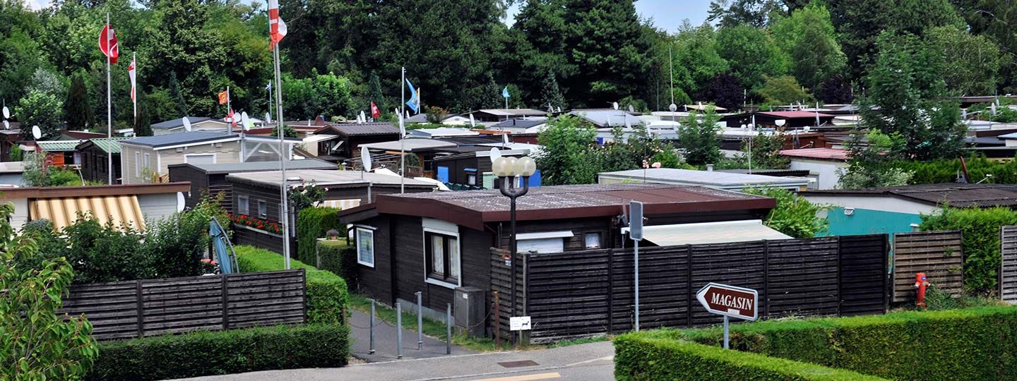 En direction du magasin, bord du lac, plage et piscine depuis la zone du camping de passage du camping des Pêches du Landeron